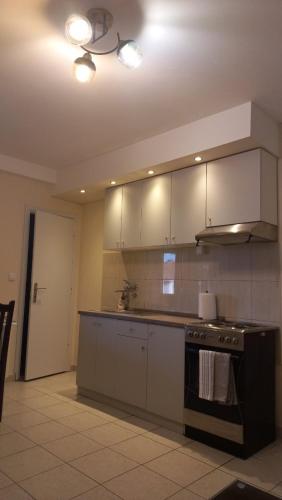 a kitchen with white cabinets and a stove top oven at ADEONA Apartments FREE PARKING in Sremska Kamenica