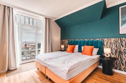 a bedroom with a large bed and a window at Hotel Hüttmann in Norddorf
