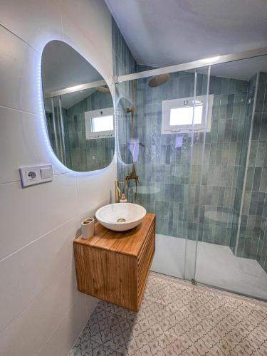 a bathroom with a sink and a shower with a mirror at Loft Deluxe Torre del Pan in Olvera