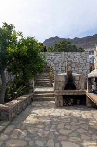 a stone stairway with a stone wall and a stone oven at Krinakia Villas in Xerokampos
