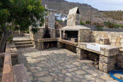 an outdoor kitchen with a stone oven and a sink at Krinakia Villas in Xerokampos