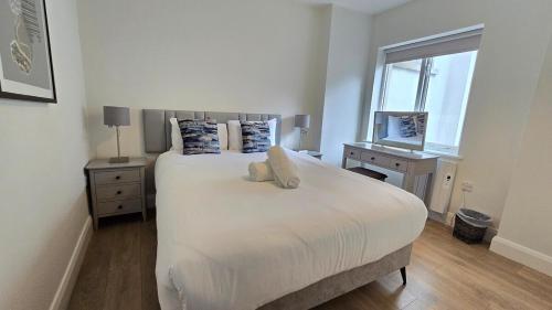 a bedroom with a large white bed and a window at Galway City Centre, 3 bedroom, sleeps 6 in Galway