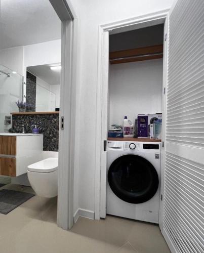 a bathroom with a washing machine and a toilet at Cotroceni Prestigious in Bucharest