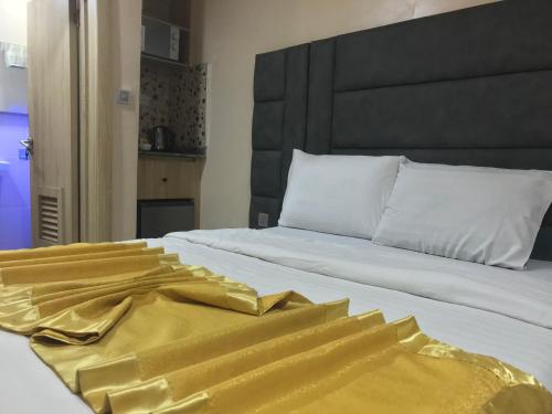 a bed with a yellow blanket on top of it at Homegate Resort in Araromi
