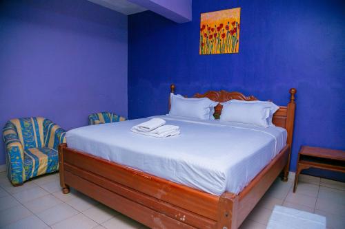 a blue bedroom with a bed with two towels on it at Malava-K-Resort in Kakamega