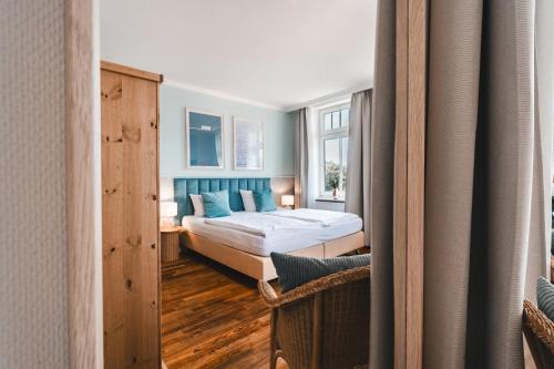 a bedroom with a bed and a window at Hotel Hüttmann in Norddorf