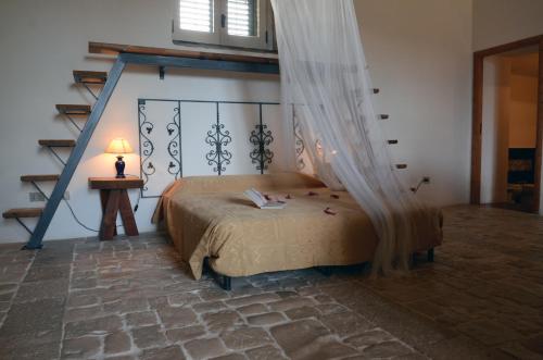 a bedroom with a bed with a mosquito net at Case Brizza in Casale Zappulla