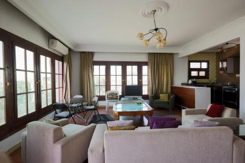 a living room with a couch and a table at Cosy Apt with Panoramic Pyramids & Museum view in Cairo