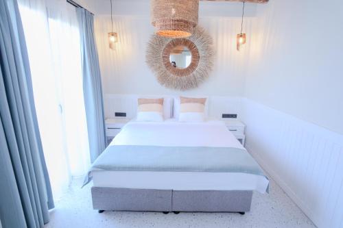 a white bedroom with a bed and a mirror at InOne Bitez Hotel in Bodrum City