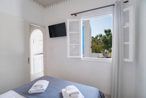 a white room with a bed and a window at Maroulis Studios Naxos in Mikri Vigla