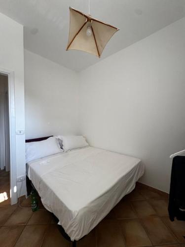 a bedroom with a white bed with a light above it at Wally in Rosa Marina