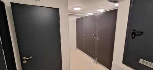 a row of lockers in a bathroom with black doors at Jacht AMBER in Gdańsk