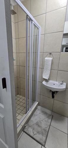 a bathroom with a shower and a sink at Grace Villas 35 in East London
