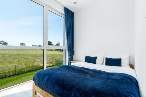 a bedroom with a bed and a large window at Apartamenty SeaLife in Sarbinowo
