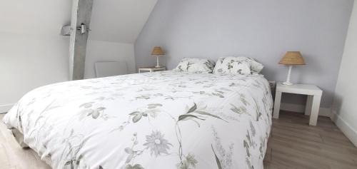 a bedroom with a bed with a white blanket with flowers at Gîte AnjouLoire in Saint-Mathurin