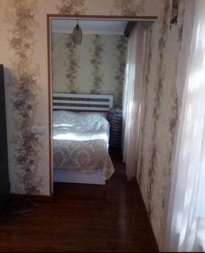 a hallway with a bed in a bedroom with wallpaper at Дом in Jermuk