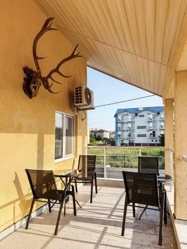 a patio with chairs and a table and a fan at Relax by the Sea Rooms next to Nibiru in Costinesti