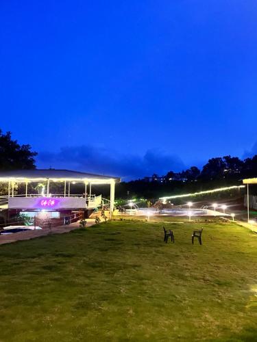 a stadium with two benches in a field at night at Glenvista Estate in Panchgani