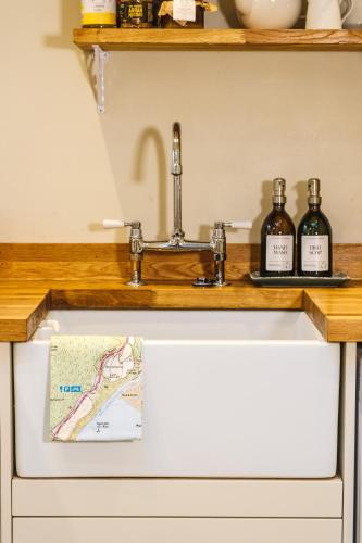 a sink in a kitchen with two bottles of wine at Craigendarroch No 2 in Acharn