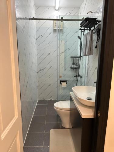 a bathroom with a shower and a toilet and a sink at Nemaru urban stay in Ho Chi Minh City