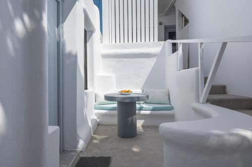 a white room with a table and a chair at Flaskos Luxury Suites in Agios Stefanos
