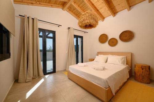 a bedroom with a large bed and a window at Olive Trees Villas in Episkopianá