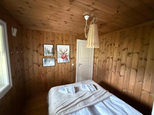 a bedroom with a bed in a wooden room at Gausta Lodge med elbillader, nærhet til Gaustatoppen Ski in ski out in Gaustablikk