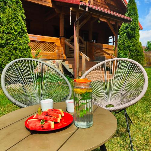a table with a plate of watermelon and a vase on it at Mazurski oddech in Zgon