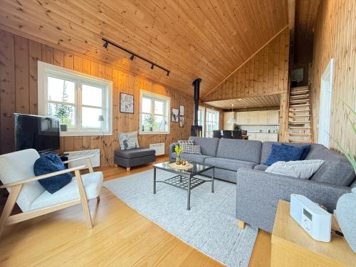 a living room with a couch and a table at Gausta Lodge med elbillader, nærhet til Gaustatoppen Ski in ski out in Gaustablikk