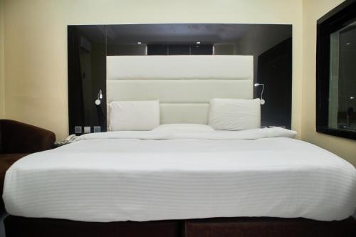 a large white bed in a hotel room at Royalbirds Hotel & Towers in Akure