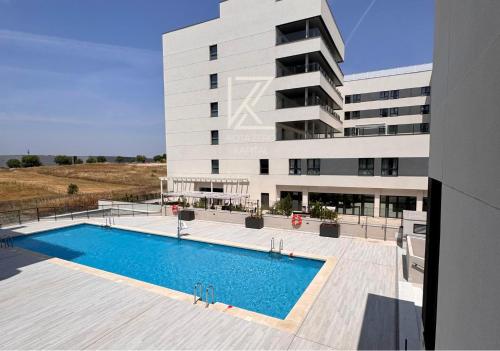 a building with a swimming pool in front of a building at KOTA Zero Rivas Center 478 in Rivas-Vaciamadrid