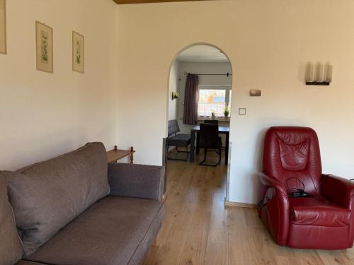 a living room with a couch and a red chair at Ferienwohnung Feßler in Steingaden