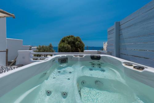 a jacuzzi tub on the back of a house at Flaskos Luxury Suites in Agios Stefanos