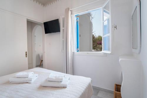 a white room with a bed and a bath tub at Maroulis Studios Naxos in Mikri Vigla