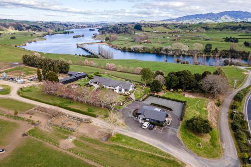 an aerial view of a house next to a river at Lakeview Lodge Karapiro in Cambridge