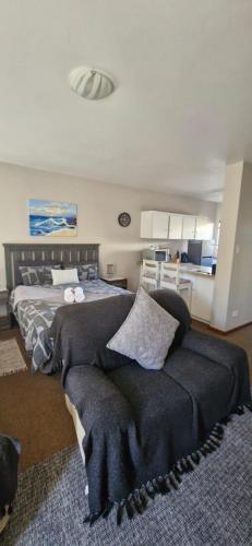 un dormitorio con una cama y un sofá en 5 Bayview Gonubie Seaside, en Gonubie