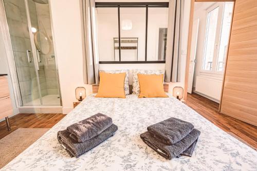 une chambre avec un grand lit avec deux oreillers dans l'établissement Charme de l'ancien pour cet appartement entièrement rénové rue jeanne d'arc, à Reims