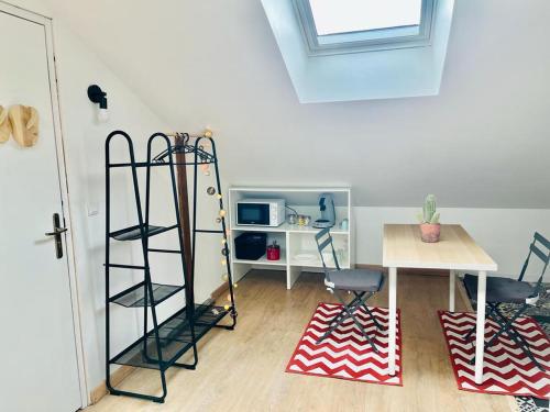 une chambre avec une table, des chaises et une étagère dans l'établissement Chavalliaud 10 studio cosy à 2 pas du centre, à Reims