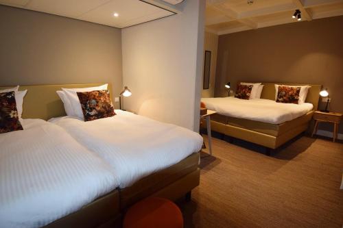 a hotel room with two beds in a room at Hotel Spaander BW Signature Collection in Volendam
