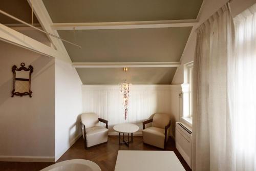 a room with two chairs and a table and a window at Hotel Spaander BW Signature Collection in Volendam