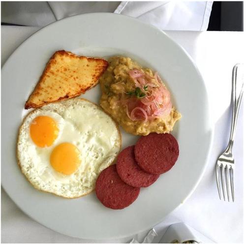 un plato de desayuno con salchichas y tostadas en Hampton Hill La Loma - Escapada Natural, Santiago RD, 