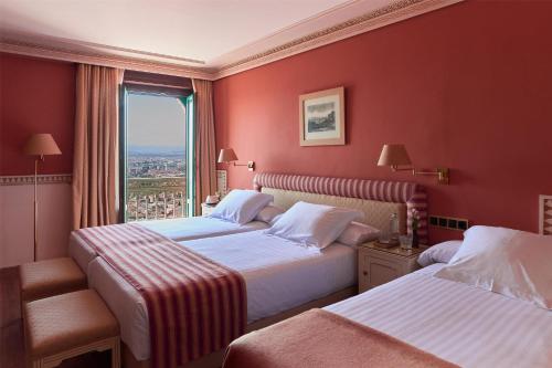 A bed or beds in a room at Alhambra Palace Hotel