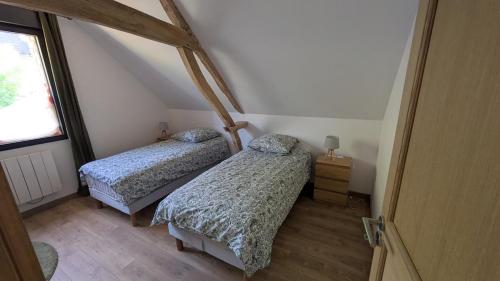 two twin beds in a room with a window at Le nid d'hirondelle in Sainneville-sur-Seine