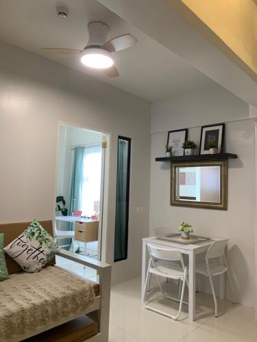 a living room with a bed and a table at Modern Condo, Sea View, Fast Wifi, Cafe, Panglao in Dauis