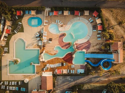 une vue aérienne d'une piscine dans un complexe hôtelier dans l'établissement Domaine Les Mûriers, à Vendres-Plage