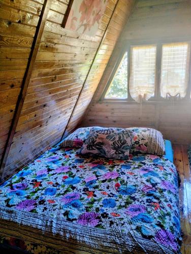 a bed in a room with a wooden wall at Domek letniskowy in Antonowo
