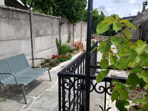 a blue bench sitting next to a fence at L'ESTAMPE in Auvers-sur-Oise