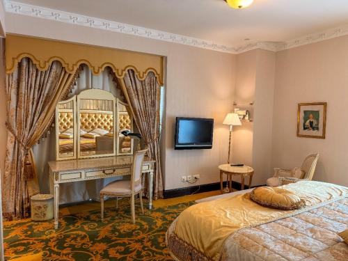 a bedroom with a bed and a mirror and a tv at Habitat Hotel All Suites - Jeddah in Jeddah