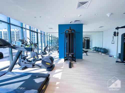 a gym with treadmills and cardio equipment in a building at Tranquil 1BR Escape with Pool View in Meydan in Dubai