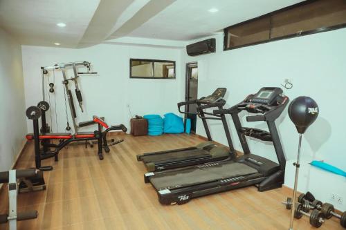 a gym with two treadmills and two exercise bikes at Vulcan suites 2bedroom in Mobushipe